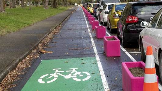 The coloured boxes act as temporary bollards to create a protected cycle lane on Pioneer Highway, from Pitt St to Botanical Rd.