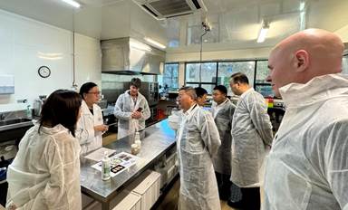 A group of people in white coats in a laboratory

Description automatically generated