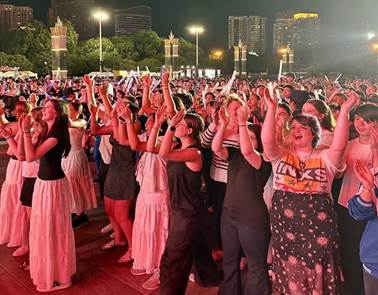 A group of people standing in a crowd
Description automatically generated