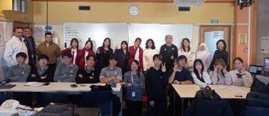 A group of people standing in a classroom
Description automatically generated